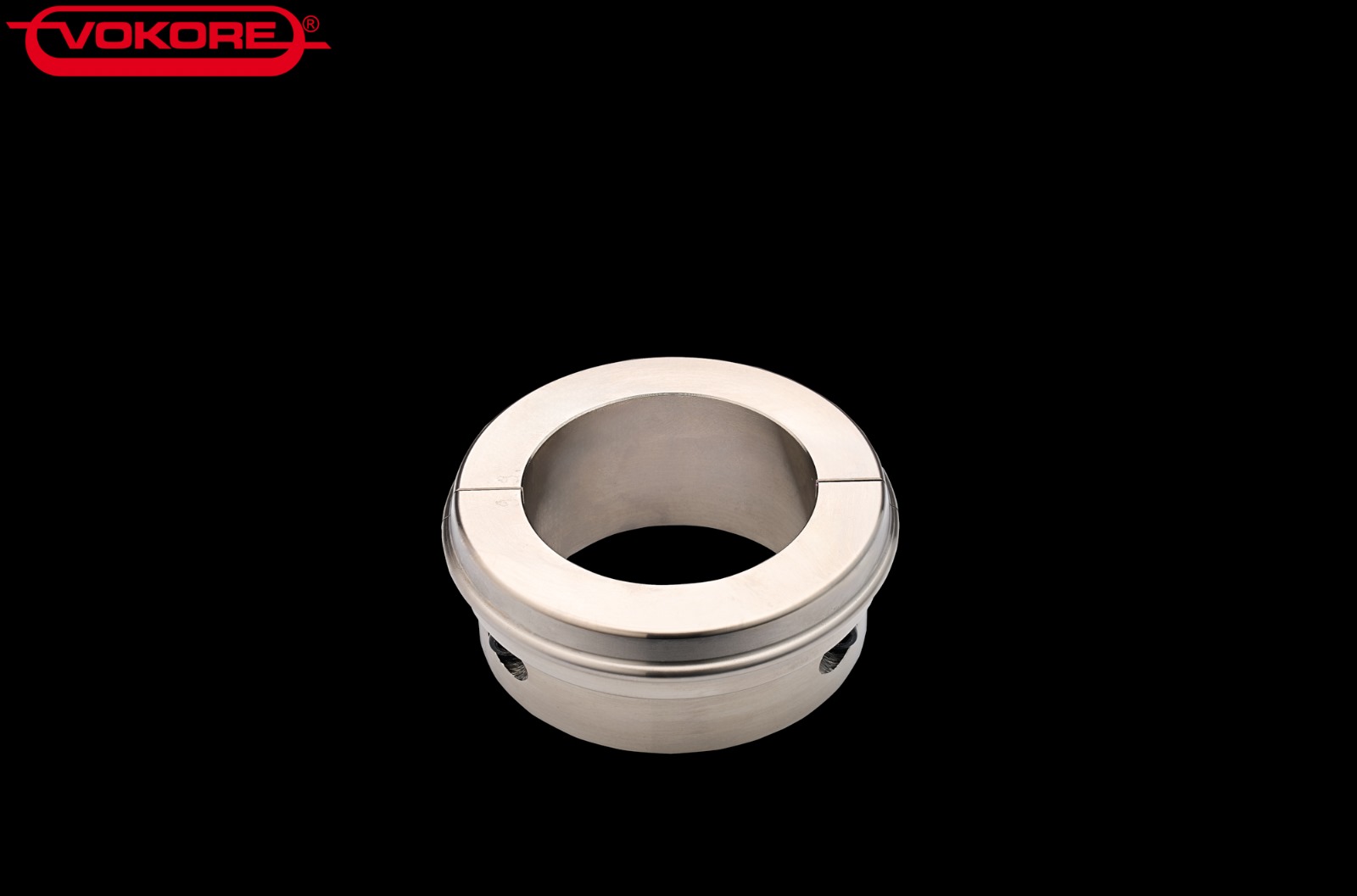 Zylindrische metallische Hülse mit zentraler Öffnung und seitlichen Bohrungen, dargestellt vor schwarzem Hintergrund