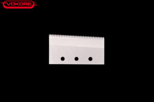 Göpfert SRE_5 Metallisches Messer mit gezahnter Schneide und vier Befestigungsbohrungen, dargestellt vor schwarzem Hintergrund