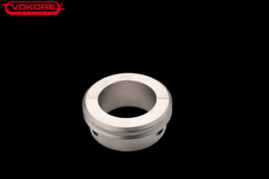 Stacked from 21 images. Method=C (S=3) Zylindrische metallische Hülse mit zentraler Öffnung und seitlichen Bohrungen, dargestellt vor schwarzem Hintergrund