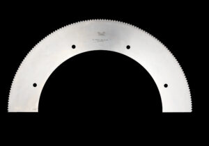 Kreisschere_1 Halbrundes Kreissägeblatt mit gezahnter Schneide und mehreren Bohrungen, dargestellt vor schwarzem Hintergrund