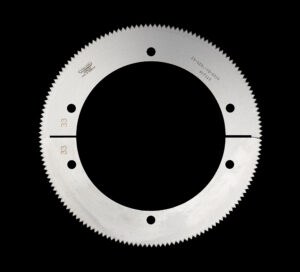 Kreisschere_2 Ringförmiges Kreissägeblatt mit gleichmäßig verteilten Bohrungen und feiner Zahnung, dargestellt vor schwarzem Hintergrund